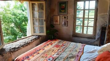 A bedroom with a bed and a window with a view video