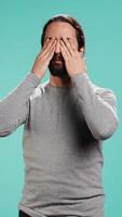 Vertical Man covering eyes, ears and mouth, imitating three wise monkeys. Arab person doing dont see, dont hear and dont speak hand gesturing concept, studio background, camera B video