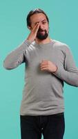 Vertical Man feeling exhausted from overworking and lack of sleep, rubbing eyes and yawning, isolated over studio background. Tired person feeling sleepy, being fatigued, studio backdrop, camera A video