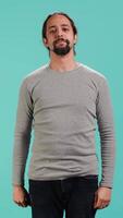 Vertical Assertive man doing stop hand gesture sign, studio backdrop. Annoyed person doing firm halt sign gesturing, wishing to end concept, isolated over blue studio background, camera A video