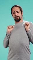 Vertical Portrait of man stretching his body, experiencing fatigue and tension in muscles. Tired person with sprained ligaments stretching limbs to relieve stress, studio background, camera B video