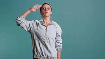 Proud female model showing the military salute with discipline and integrity, showing her patriotism and values. Stylish attractive woman symbolizing respect for soldiers and for the army. Camera B. video
