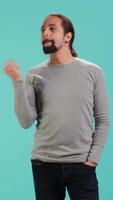 Vertical Cheerful man acting casually, exuding nonchalant and carefree demeanor. Portrait of jolly person being relaxed and at ease, showing self assuredness, studio background, camera A video