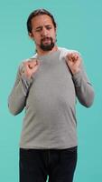 Vertical Portrait of man stretching his body, experiencing fatigue and tension in muscles. Tired person with sprained ligaments stretching limbs to relieve stress, studio background, camera A video