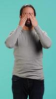 Vertical Man covering eyes, ears and mouth, imitating three wise monkeys. Arab person doing dont see, dont hear and dont speak hand gesturing concept, studio background, camera A video