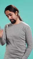 Vertical Portrait of troubled man feeling saddened and rattled by bad news, isolated over studio backdrop. Distressed person on the verge of crying, left speechless by troubling events, camera B video