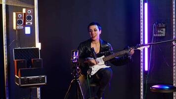 Voice training instructor teaching people to play the guitar on online lesson live tutorial, doing a practice session during virtual class. Superstar vocal coach does singing lessons. Camera B. video