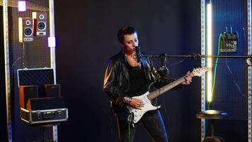 Fierce rock singer performs live singing into the microphone with passion. Cool edgy artist with rebellious energy creating a wild iconic performance in the heavy metal music industry. Camera B. video