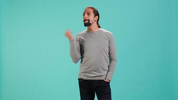 Cheerful man acting casually, exuding nonchalant and carefree demeanor. Portrait of jolly person being relaxed and at ease, showing self assuredness, studio background, camera A video