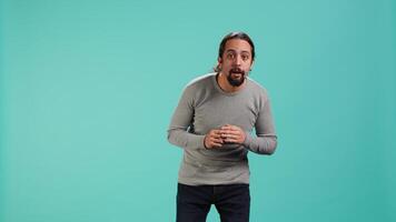 Portrait of wide eyed man looking in awe, captivated by what he sees, isolated over studio background. Excited curious person being in complete admiration, unable to believe eyes, camera A video