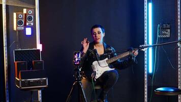 Professional artist instructor hosting a virtual singing lesson in studio, teaching people to sing and play guitar on online tutorial. Rock star doing live performance for training. Camera B. video