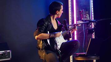 Pleased punk rock artist rehearsing for her live performance, focusing on vocal training and warm up. Edgy iconic woman enjoying singing practice with alternative music. Camera A. video