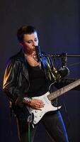 Vertical Fierce rock singer performs live singing into the microphone with passion. Cool edgy artist with rebellious energy creating a wild iconic performance in the heavy metal music industry. Camera B. video