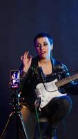 Vertical Professional artist instructor hosting a virtual singing lesson in studio, teaching people to sing and play guitar on online tutorial. Rock star doing live performance for training. Camera B. video
