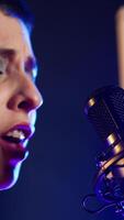 Vertical Fierce rock singer performs live singing into the microphone with passion. Cool edgy artist with rebellious energy creating a wild iconic performance in the heavy metal music industry. Camera A. video
