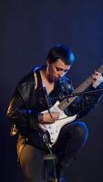 Vertical Pop star in leather jacket performs a song in a live concert hall, powerful artist with an amazing melodic voice. Bold grunge musician singing alternative music for a show. Camera B. video