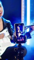 Vertical Social media artist live streaming a song for her music vlog, live event vocal performance online on internet. Content creator doing a broadcast for fan engagement, online concert. Camera A. video