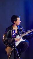 Vertical Voice training instructor teaching people to play the guitar on online lesson live tutorial, doing a practice session during virtual class. Superstar vocal coach does singing lessons. Camera A. video