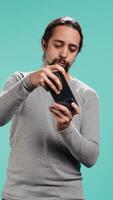 Vertical Man playing intense singleplayer videogames on smartphone, enjoying hobby. Gamer enjoying entertaining interactive game on phone, having fun, isolated over studio background, camera B video