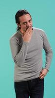 Vertical Frisky playful man blowing kisses to camera, being flirty. Lively charming person having fun sending air kisses, doing romantic gesturing, isolated over studio background, camera A video