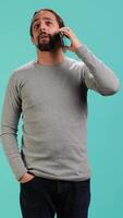 Vertical Man discussing with best friend over telephone call using smartphone, studio backdrop. Person talking with mate in phone call using cellphone, isolated over studio background, camera A video