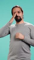 Vertical Man feeling exhausted from overworking and lack of sleep, rubbing eyes and yawning, isolated over studio background. Tired person feeling sleepy, being fatigued, studio backdrop, camera B video
