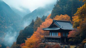 Traditional Japanese House Nestled in Misty Autumnal Mountains photo