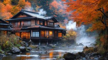 Traditional Japanese House by a Misty River in Autumn Foliage photo