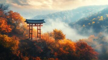 A Red Torii Gate Stands on a Cliff Overlooking a Misty Forest in Autumn photo