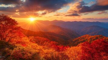 Sunset over a mountain range with vibrant autumn foliage photo