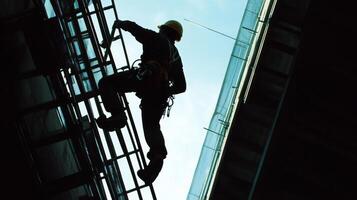 Silhouetted Construction Worker Ascending a Metal Ladder photo