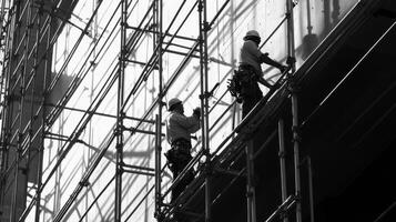 Two Construction Workers on Scaffolding Against a Wall photo