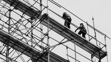 Two Construction Workers on Scaffolding in Black and White photo