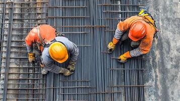 Two Construction Workers Bending Steel Rebar for a Concrete Foundation photo