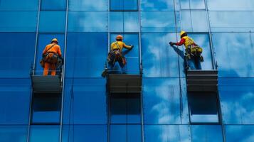 Three Window Washers Hanging From Scaffolding On A Modern Building photo