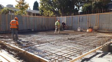 Construction Workers on Concrete Slab with Rebar Grid photo