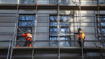 Two Construction Workers on Scaffolding During Building Renovation photo
