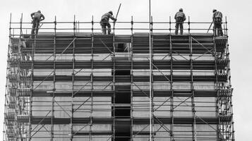 Four Construction Workers on Scaffolding of a High-Rise Building photo