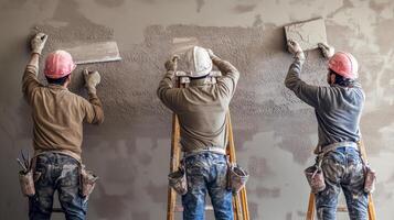 Three Construction Workers Applying Plaster to a Wall photo