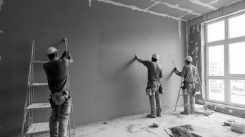 Three Construction Workers Applying Plaster to Wall in Unfinished Room photo