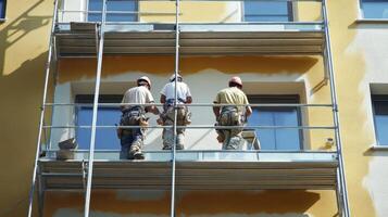 Three Workers on Scaffolding Painting a Building Facade photo