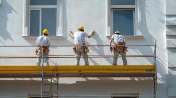 Three Construction Workers on Scaffolding During Building Renovation photo
