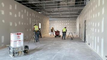 Construction Workers Finishing Interior Walls of a Building photo
