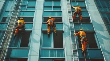 Workers in orange suits cleaning windows on a tall building photo