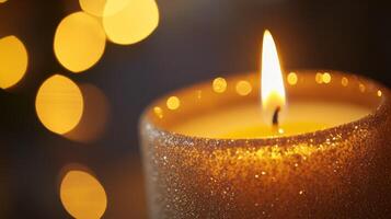 A Lit Glittery Candle with a Warm Glow and Blurry Lights in the Background photo