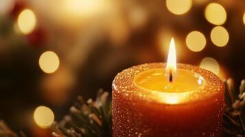A Single Glittery Candle with a Flame, Surrounded by Warm Bokeh Lights photo