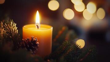 A Candle Burning Brightly Amidst Evergreen Branches and Bokeh Lights photo