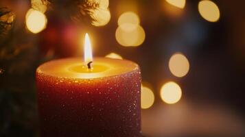A Single Lit Candle With a Red Glittery Body Surrounded by Warm Bokeh Lights photo