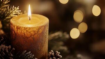 A Single Lit Candle with Snowy Pine Branches and Bokeh Lights photo