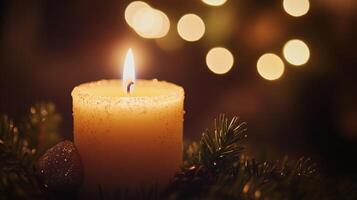 A Single Candle Glowing Amidst Pine Branches and Blurry Lights photo